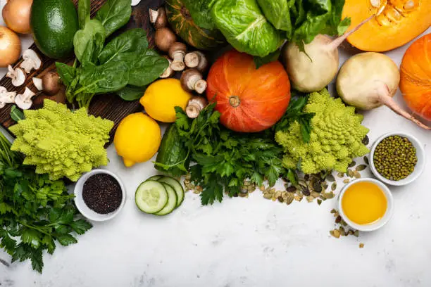 Photo of Different vegetables and greens on the white background.