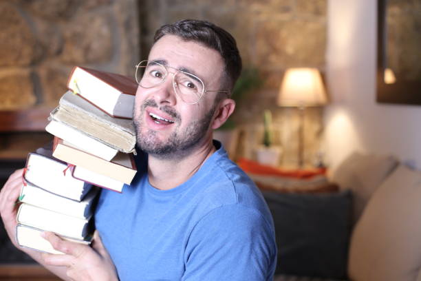 istock Man holding heavy pile of books 1296029551