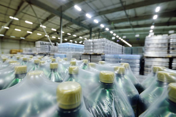 istock huge industrial warehouse with plastic food wrap wrapped plastic bottles with carbonated drinks, water or beer. 1296033911