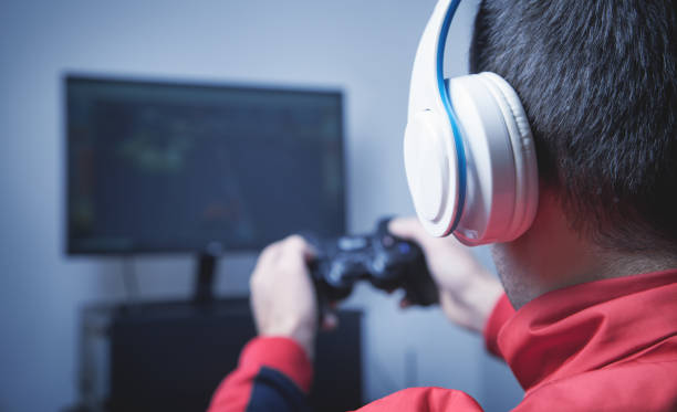 istock Man playing video game in home. 1296035023
