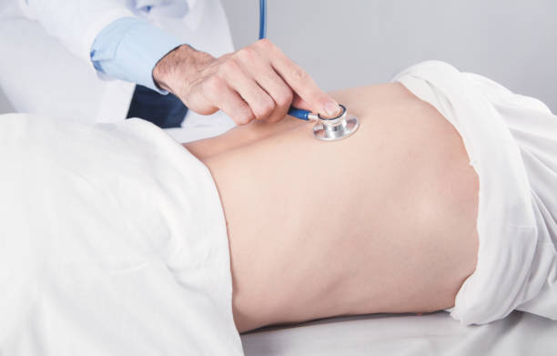 istock Doctor checking patient back with stethoscope at hospital. 1296035043
