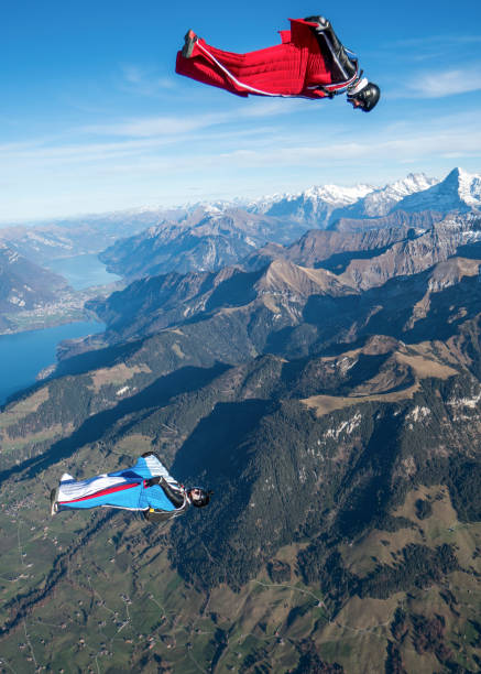 istock Wing suit fliers glide through clear skies 1296035432