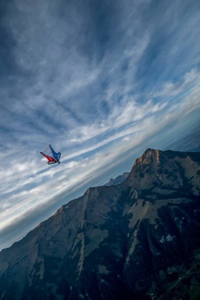 l’aviateur de costume d’aile vole par le ciel clair le matin - wingsuit photos et images de collection