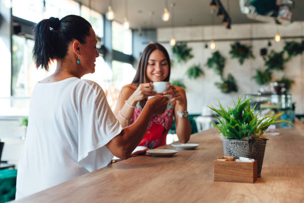 istock Mom And Daughter Drinking Coffee In A Cafe 1296036542
