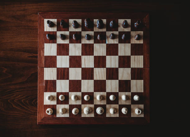 istock Overhead view of wooden chess board and pieces on a table. 1296036687