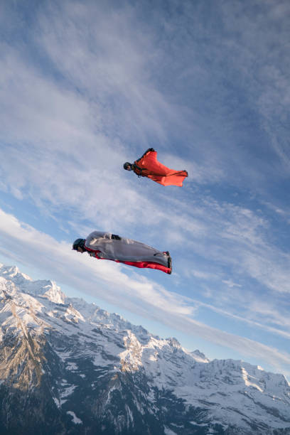 istock Wing suit fliers fall through clear skies 1296036725