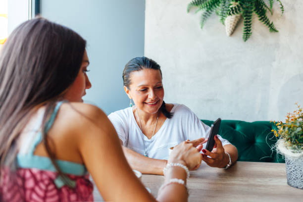 istock Mother And Daughter Women Using A Mobile Phone 1296036822