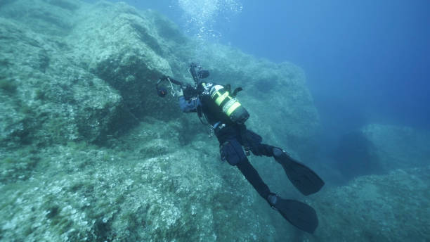 istock Scuba diver carrying underwater camera explores reefs 1296036860