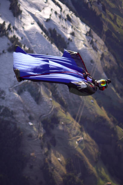 istock Wing suit flier falls through clear skies upside down 1296037033