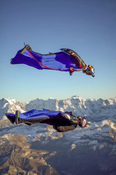 istock Wing suit fliers fly through clear skies 1296037105