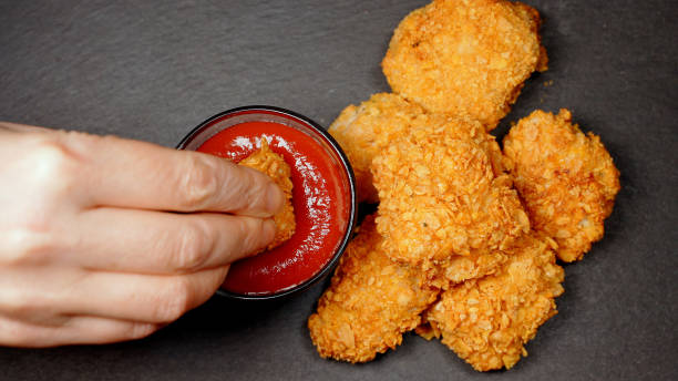 istock Girl tries nuggets with ketchup. 1296040666