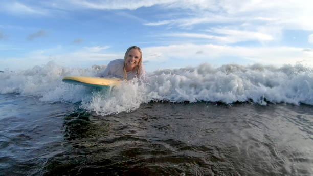 vista da mulher boogie-boarding através de água branca na parte da manhã - bodysurfing - fotografias e filmes do acervo