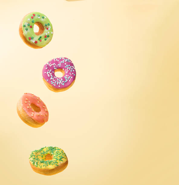 istock Real Flying donuts. Mix of multicolored doughnuts on yellow background. 1296042887