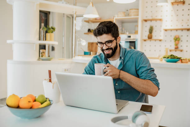 istock Young man is working from home on laptop and drinking coffe 1296043916