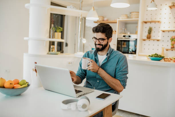 istock Young man is working from home on laptop and drinking coffe 1296043929