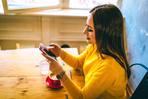 istock Woman drinking coffee and using mobile phone 1296045032
