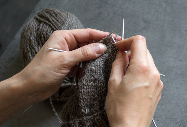 istock Woman hands knitting socks 1296046044