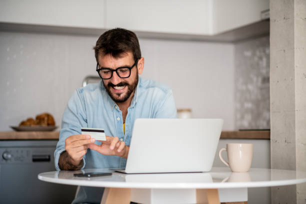 istock Young man uses his credit card. 1296046444