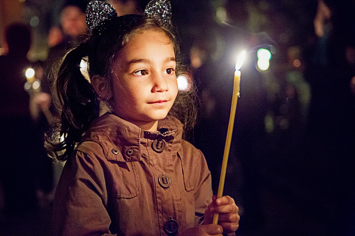 Portrait of little girl holding candle at religious celebration