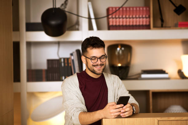 istock Young male standing and typing message on the phone 1296049616