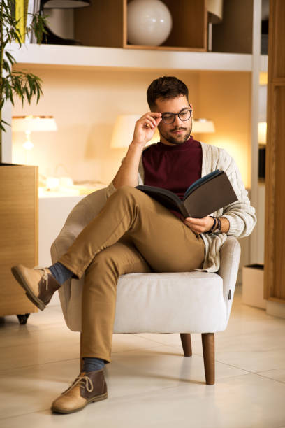 istock Young male sitting and reading book 1296049766