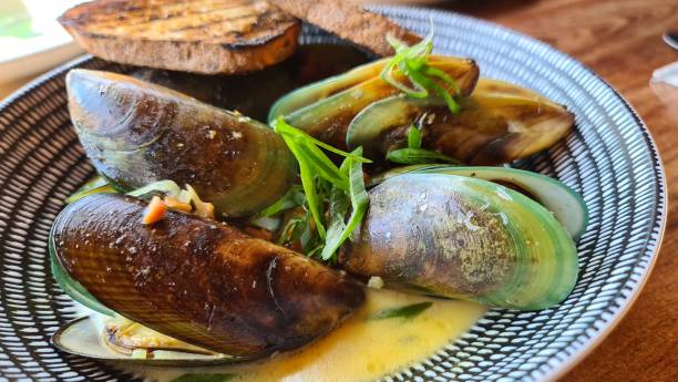 istock Close-up of green lipped mussels in white wine dish 1296050607