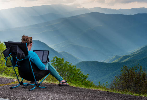 istock Woman Works on Tablet While Sitting at Overlook 1296055226