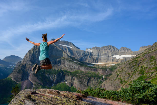 女性は山の景色でジャンプ - exploration mountain ice jumping ストックフォトと画像