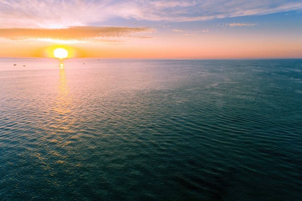 istock Aerial view of sun setting over calm ocean water 1296060169