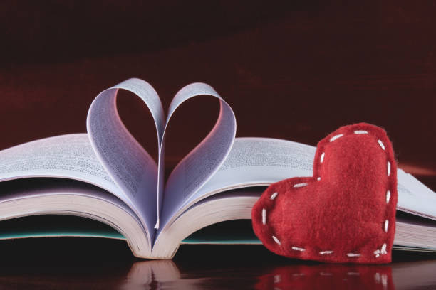 istock Valentines day background with open book and heart-shaped pages.. 1296063803