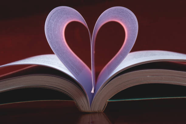 istock Valentines day background with open book and heart-shaped pages.. 1296063807