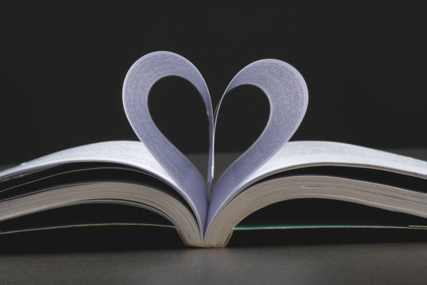 istock Valentines day background with open book and heart-shaped pages.. 1296063871