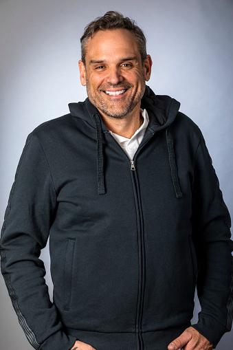 Portrait with hoodie in a studio smiling