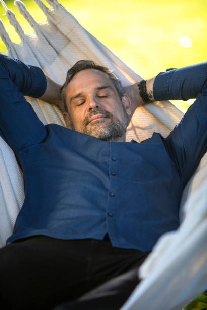 istock Man sleeping in a hammock outdoors 1296066120