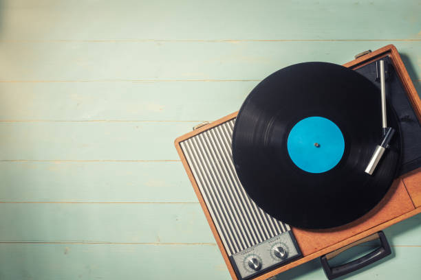 istock Old turntable with a vinyl record on wooden table 1296067678