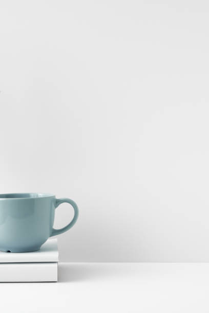 istock The mug stands on a stack of books on a white background. Natural and eco-friendly materials. Copy space, mock up. 1296068599