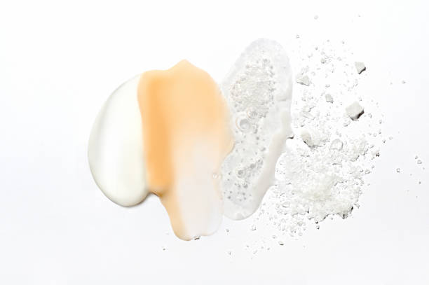 Mix of textures of cream, lotion, liquid gel and sea salt on a white background close-up. Mixed samples of beauty products. Smeared makeup, sprinkled salt, concealer and foundation smears. Mix of textures of cream, lotion, liquid gel and sea salt on a white background close-up. Mixed samples of beauty products. Smeared makeup, sprinkled salt, concealer and foundation smears shower gel photos stock pictures, royalty-free photos & images