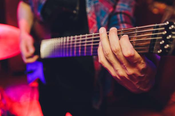 istock electric guitar close up with fingers playing it. 1296068902