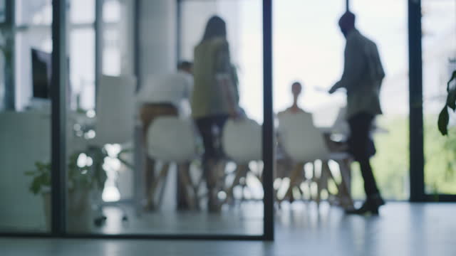 4K-Videoaufnahmen von nicht erkennbaren Geschäftsleuten, die sich nach der Ankunft zu einem Meeting in einem modernen Büro die Hand schütteln