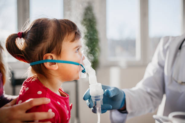 istock Asthma, little girl with inhaling mask 1296076331