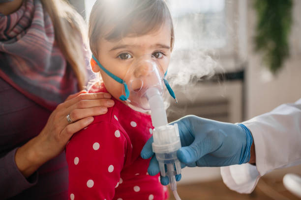 asthma, kleines mädchen mit einatmen maske - asthmatic child asthma inhaler inhaling stock-fotos und bilder