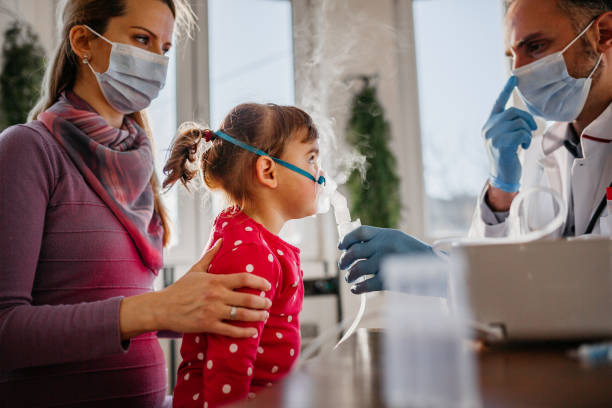 The doctor helping child to put nebulizer inhaler face mask doctor general practitioner helping child to put nebulizer inhaler face mask pediatric nebulizer mask stock pictures, royalty-free photos & images