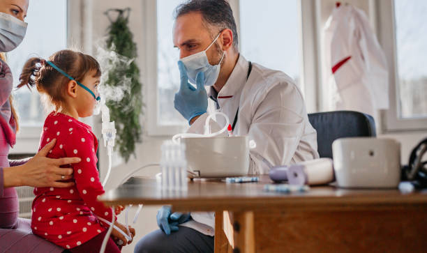 The doctor helping child to put nebulizer inhaler face mask doctor general practitioner helping child to put nebulizer inhaler face mask pediatric nebulizer mask stock pictures, royalty-free photos & images