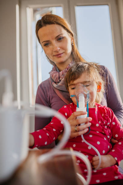 Mom and baby girl with nebulizer Mom and baby girl nebulizer pediatric nebulizer mask stock pictures, royalty-free photos & images