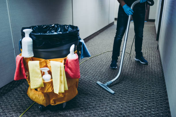 Janitor vacuum cleaning the corridor of an office building. stock photo