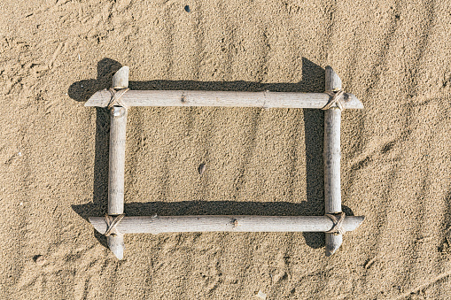 Frame of wood lying on the sand
