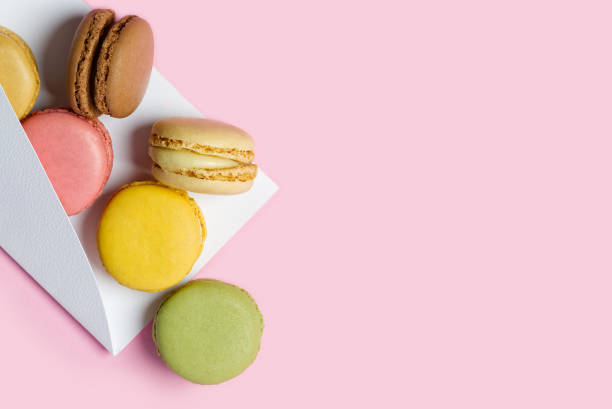 istock Colorful macarons like a gift on pink background with copy space 1296079869