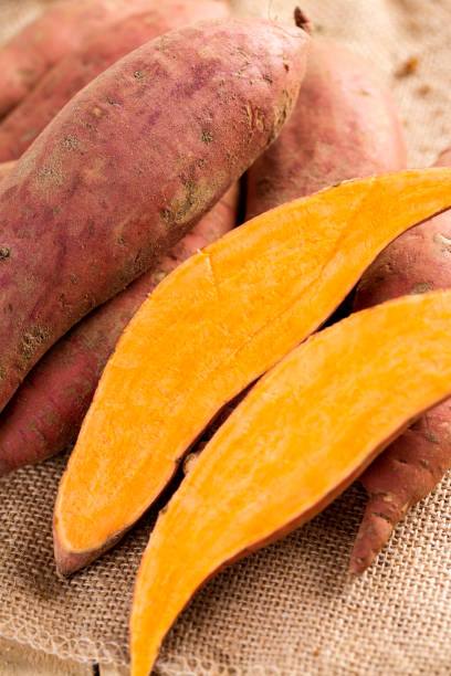 istock Raw sweet potato on wood background 1296079871