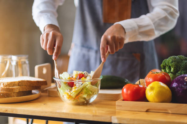 istock a female chef cooking fresh mixed vegetables salad in kitchen 1296083662