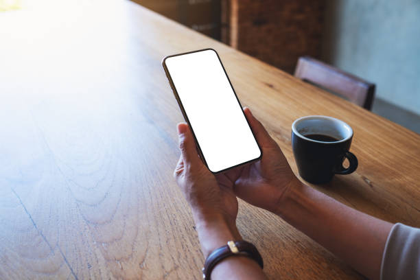 istock a woman holding mobile phone with blank white desktop screen 1296083679